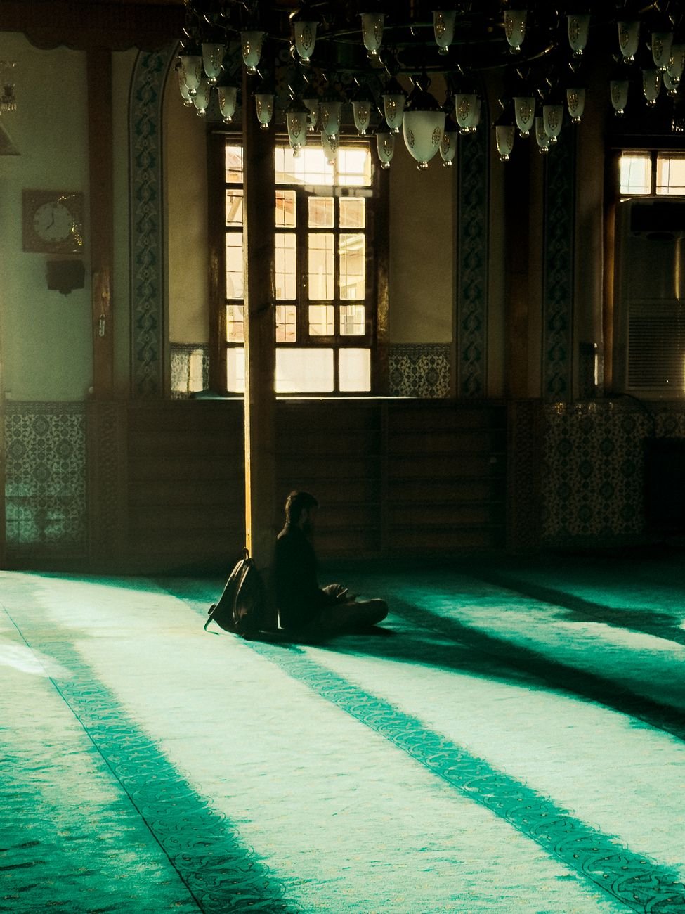 A person in quiet prayer and meditation within a peaceful, light-filled interior space